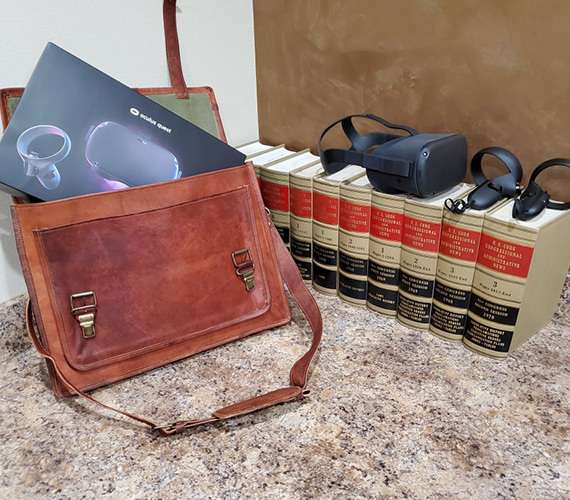 A Meta Quest VR headset and controllers next to a shelf of legal law books